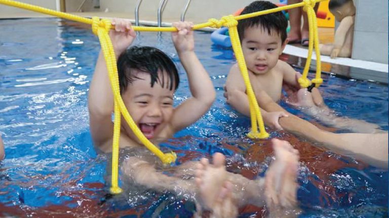 2.5-3.5歲幼兒使用特殊教具 (aquaMoov 水中體能教學系統) 進行繩索抓握與平衡練習，在遊戲中強化上肢肌力與核心穩定度，將體適能融入游泳教學。