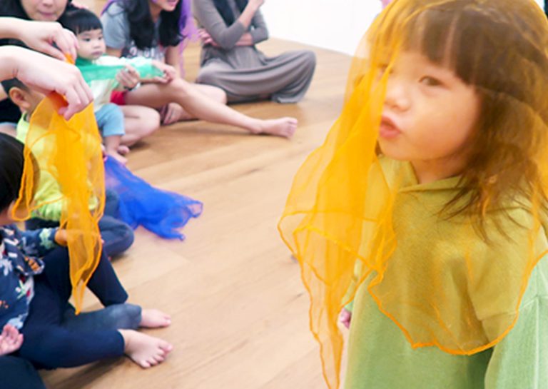 孩子們在教練引導下玩絲巾遊戲,透過觀察絲巾緩慢飄落的路徑,訓練眼球的視覺追蹤 (Visual Tracking) 能力與專注力,屬於靜態的感統訓練。
