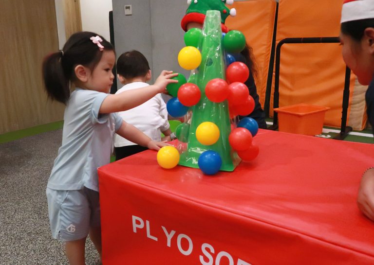 幼兒將彩球塞入特殊的樹狀裝置中,這項活動專注於訓練手指的精細動作 (Fine Motor Skills)、手眼協調以及顏色配對認知。
