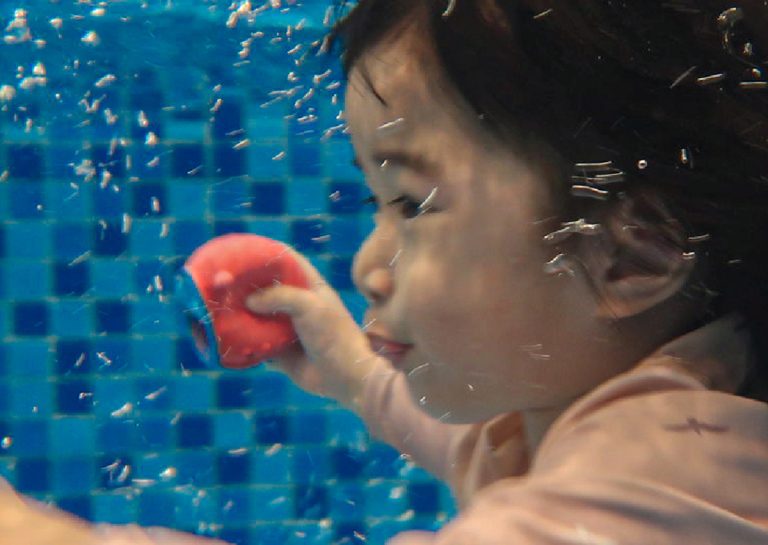 幼兒在水中潛水並睜眼抓取沉底玩具,展示出色的水中物體辨識與閉氣控制 (Breath Control) 能力,提升水中探索自信。