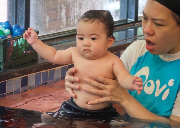 專業教練輔助幼兒在淺水區練習站立與動態平衡,透過專業引導建立孩子對水深變化的適應力與安全感。