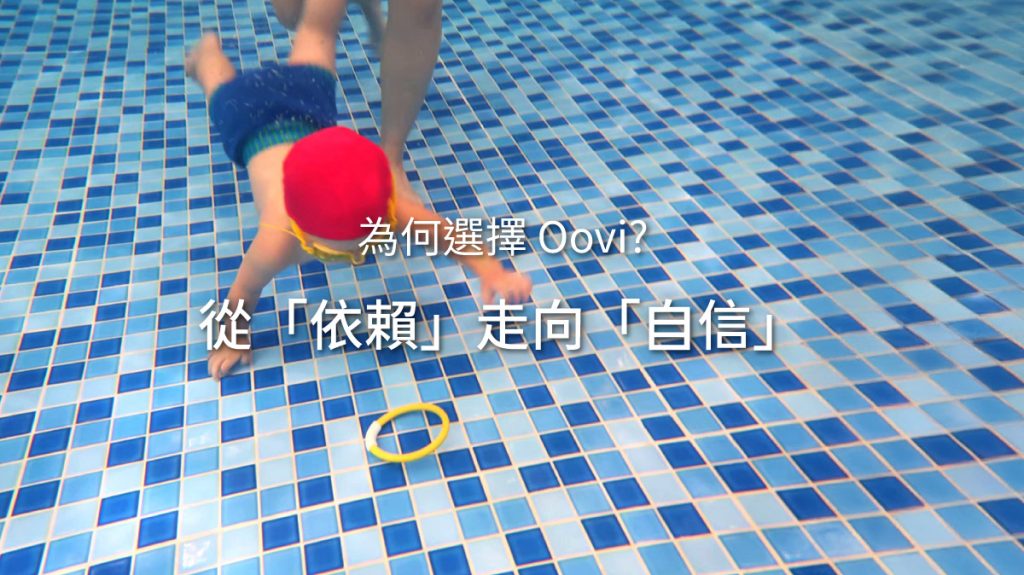 幼兒潛入水中抓取玩具,圖片壓字**「為何選擇 Oovi?從『依賴』走向『自信』」。這張圖象徵 Oovi 的教學理念,透過循序漸進的游泳課程,幫助孩子擺脫對浮具與家長的依賴**,建立獨立解決問題的水中自信 (Water Confidence)。