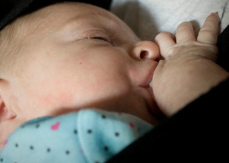 捕捉寶寶在揹巾內親餵母乳 (Breastfeeding in Carrier) 的特寫畫面,展示揹巾穿戴提供的極佳隱密性與便利性,支持母乳媽媽達成隨需哺餵 (Feeding on demand) 的育兒目標。
