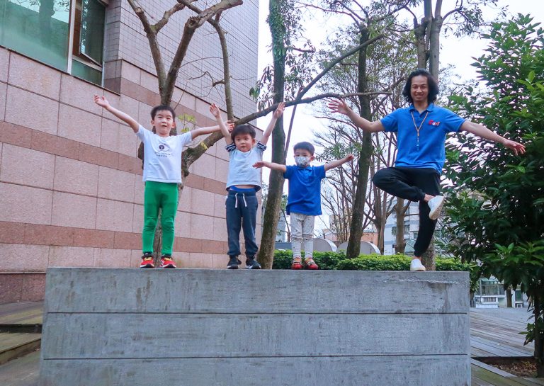 Oovi 營隊師生在戶外石台上練習平衡站立與姿勢控制,透過自然環境中的體能挑戰,培養孩子在不同地形中的肢體自信。