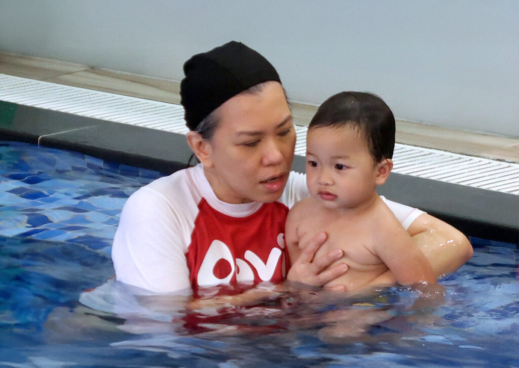 Diana 老師將寶寶抱在胸前,在水中輕聲細語地安撫與引導。畫面傳遞出老師平穩、安定且充滿愛的特質,讓初次接觸泳池的幼兒能在最溫馨的環境下開始學習。