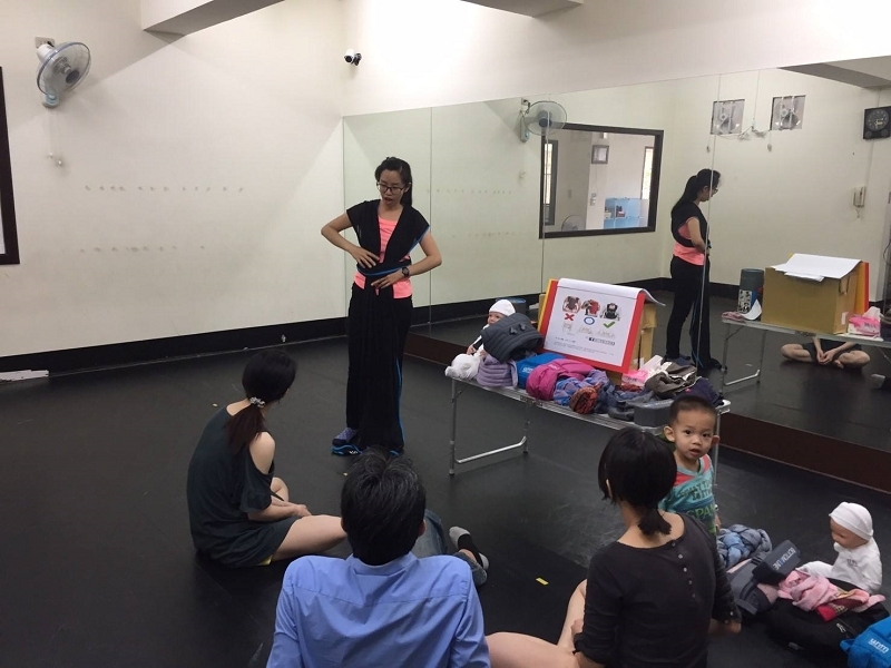 台南揹巾輔導員Lisa在麵攤工作時,將孩子穩固地揹在背上,展現多工能力
